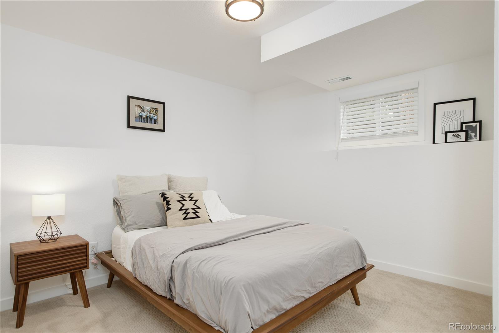 95 Fitzsimmons Road Bailey, CO 80421 - Photo 25 of 38 a bedroom with a bed and a lamp on the dresser