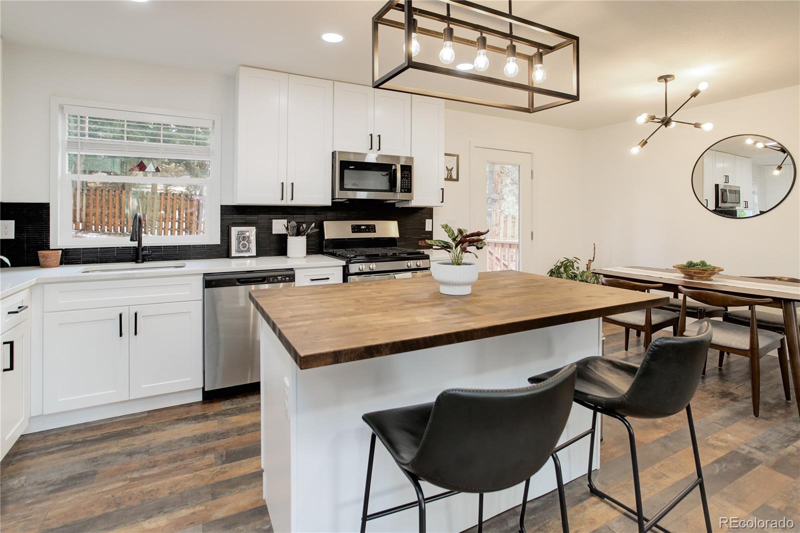 95 Fitzsimmons Road Bailey, CO 80421 - Photo 6 of 38 a kitchen with a table chairs stove and microwave