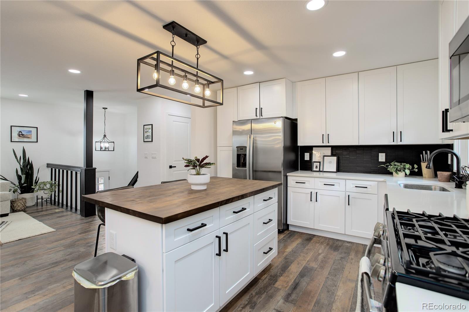 95 Fitzsimmons Road Bailey, CO 80421 - Photo 8 of 38 a kitchen with stainless steel appliances a stove a sink dishwasher a refrigerator white cabinets and wooden floor