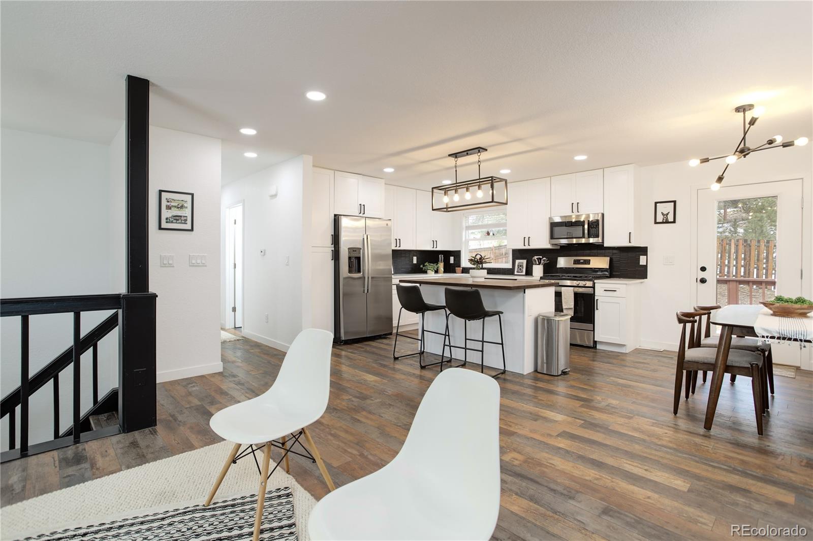 95 Fitzsimmons Road Bailey, CO 80421 - Photo 10 of 38 a dining room with stainless steel appliances kitchen island granite countertop a dining table chairs and a refrigerator