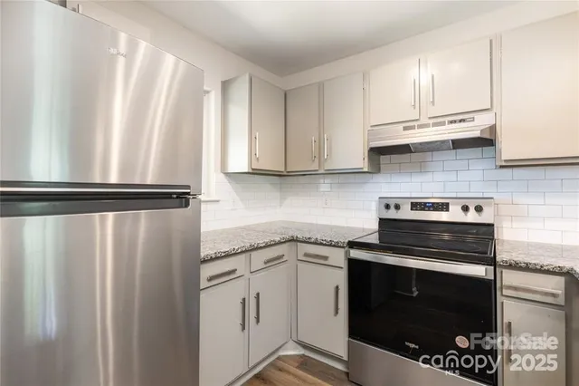 a kitchen with stainless steel appliances granite countertop a refrigerator stove and sink