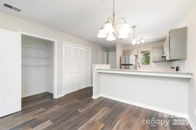 a large kitchen with hardwood floor and a view of living room