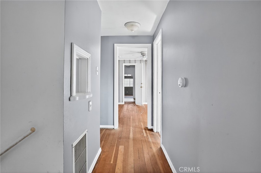 1717 Locust Ravine Bakersfield, CA 93306 - Photo 21 of 29 a view of a hallway with wooden floor and a bathroom