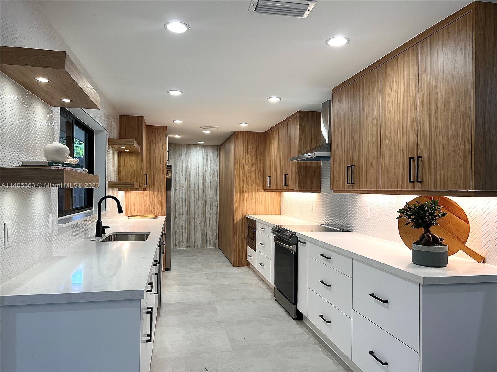 1201 Northwest 3rd Avenue Boca Raton, FL 33432 - Photo 3 of 29 a kitchen with a sink stainless steel appliances and cabinets
