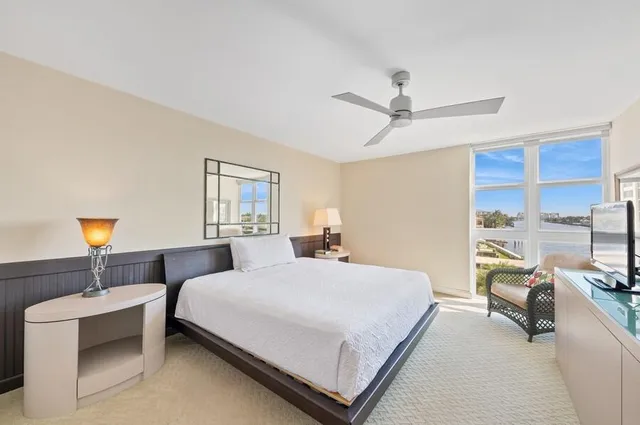 a bedroom with a bed a couch and a chandelier