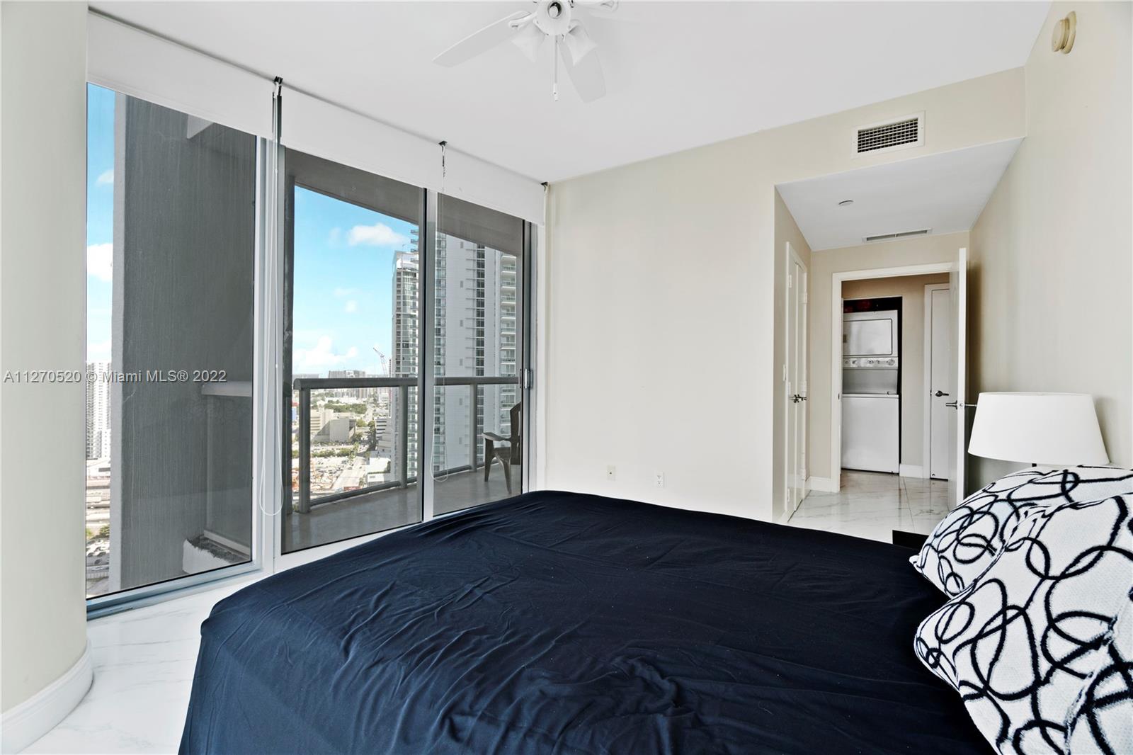 888 Biscayne Boulevard, Unit 3301 Miami, FL 33132 - Photo 14 of 29 a view of a bedroom with wooden floor and a ceiling fan