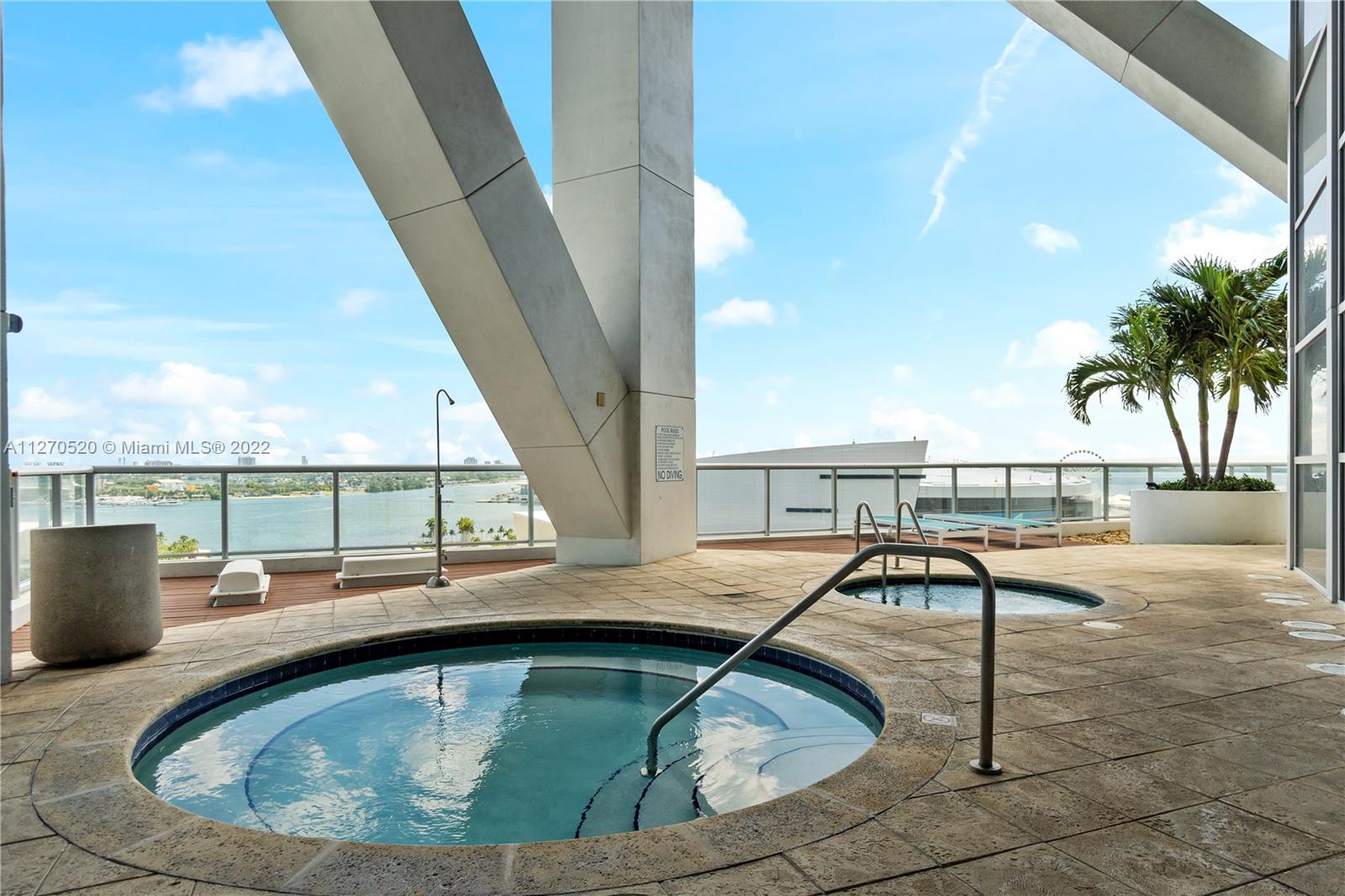888 Biscayne Boulevard, Unit 3301 Miami, FL 33132 - Photo 20 of 29 a view of a swimming pool with a lounge chair