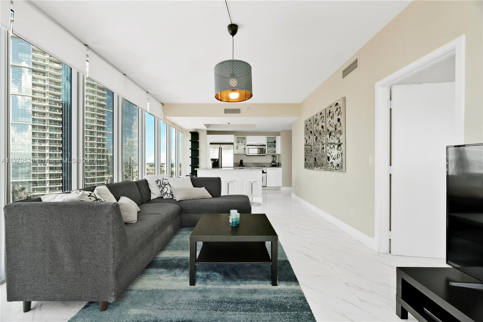 888 Biscayne Boulevard, Unit 3301 Miami, FL 33132 - Photo 2 of 29 a living room with furniture flat screen tv and a large window