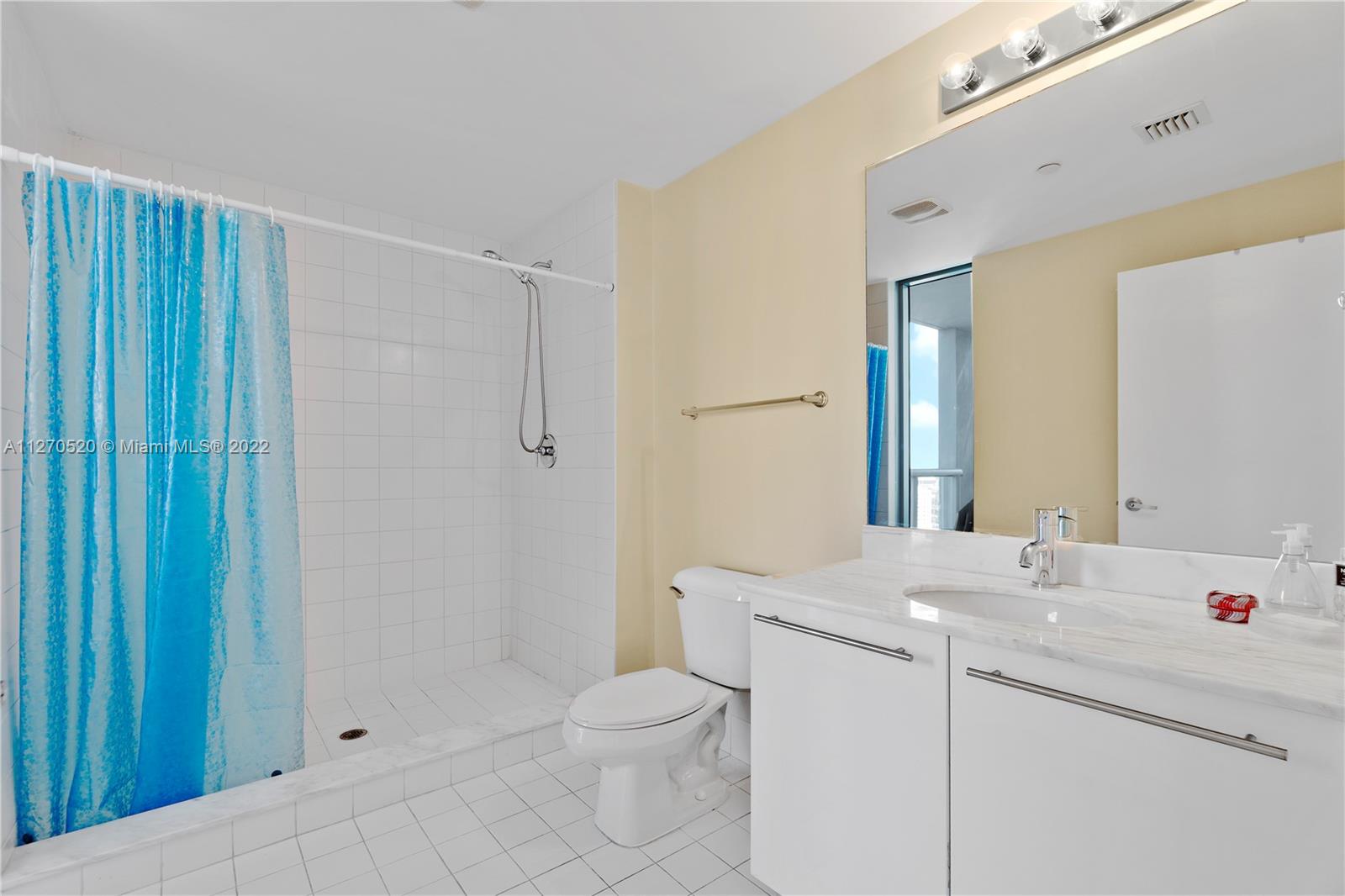 888 Biscayne Boulevard, Unit 3301 Miami, FL 33132 - Photo 24 of 29 a bathroom with a sink a toilet and shower