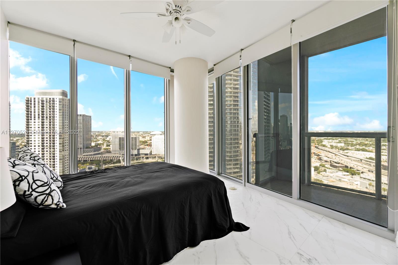 888 Biscayne Boulevard, Unit 3301 Miami, FL 33132 - Photo 25 of 29 a bedroom with a large bed and a large window