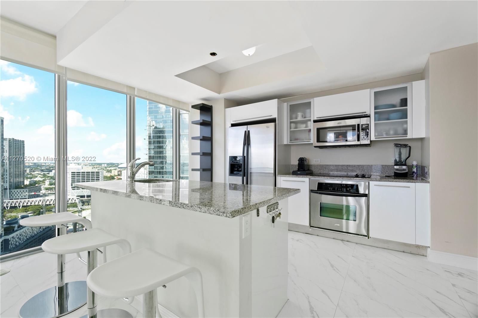 888 Biscayne Boulevard, Unit 3301 Miami, FL 33132 - Photo 5 of 29 a kitchen with stainless steel appliances granite countertop a stove and a refrigerator