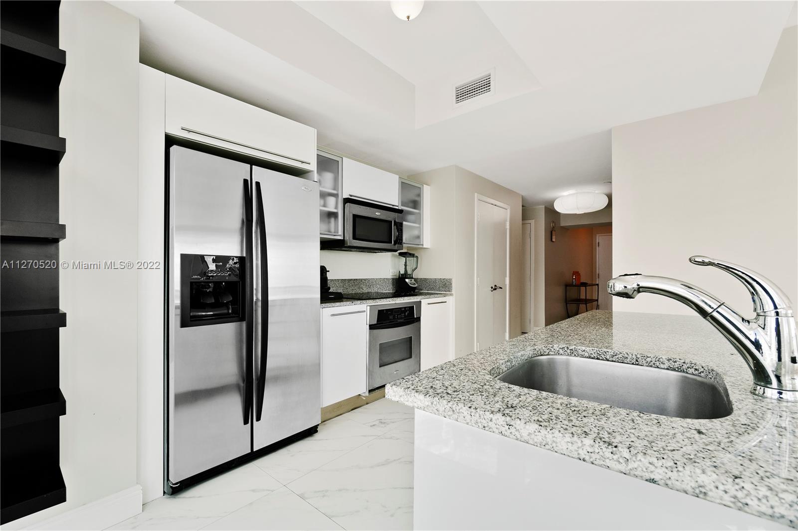888 Biscayne Boulevard, Unit 3301 Miami, FL 33132 - Photo 6 of 29 a kitchen with a refrigerator sink and cabinets