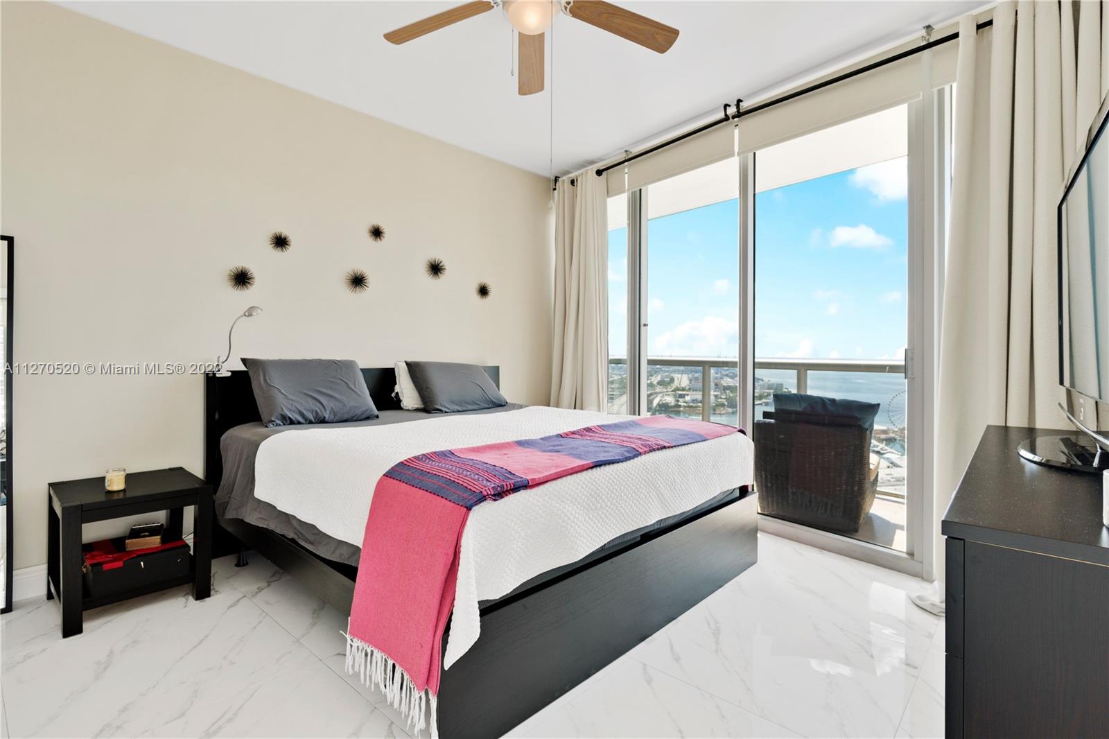 888 Biscayne Boulevard, Unit 3301 Miami, FL 33132 - Photo 7 of 29 a bedroom with a bed and a large window