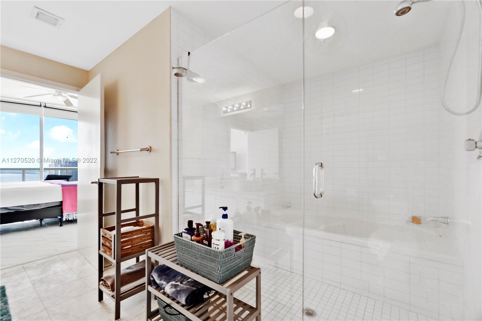 888 Biscayne Boulevard, Unit 3301 Miami, FL 33132 - Photo 10 of 29 a bathroom with a tub shower vanity and a sink