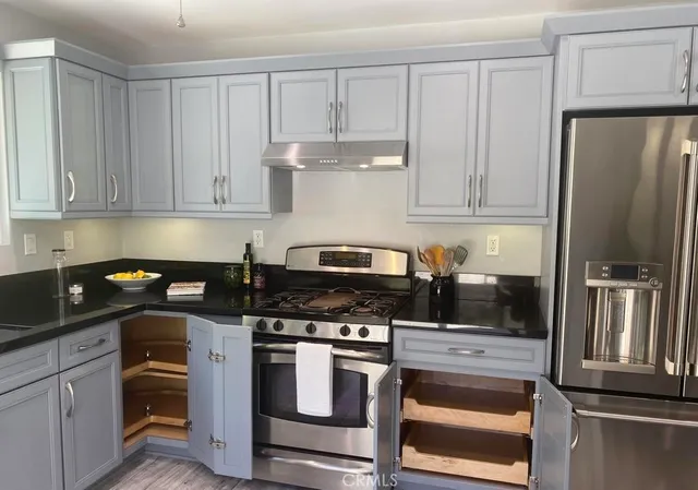a kitchen with stainless steel appliances granite countertop a refrigerator stove and sink