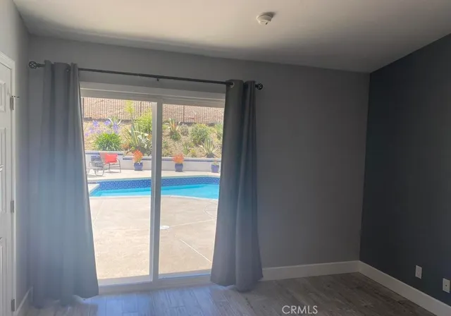 a view of an empty room and wooden floor and windows