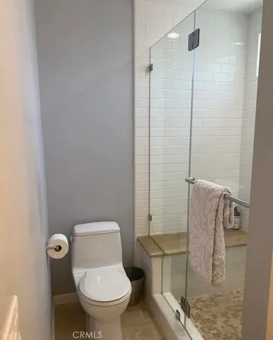 a white toilet sitting next to a bathroom sink and a shower