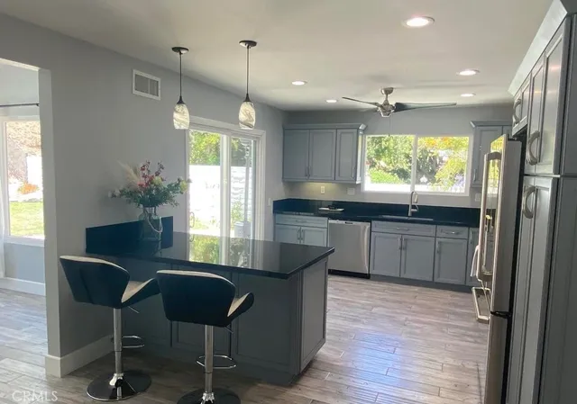 a kitchen with granite countertop a stove a sink and a refrigerator