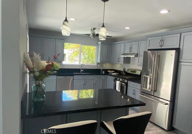 a kitchen with stainless steel appliances granite countertop a sink refrigerator and microwave