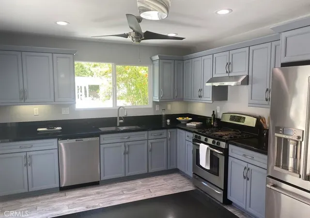 a kitchen with stainless steel appliances granite countertop a sink stove and refrigerator