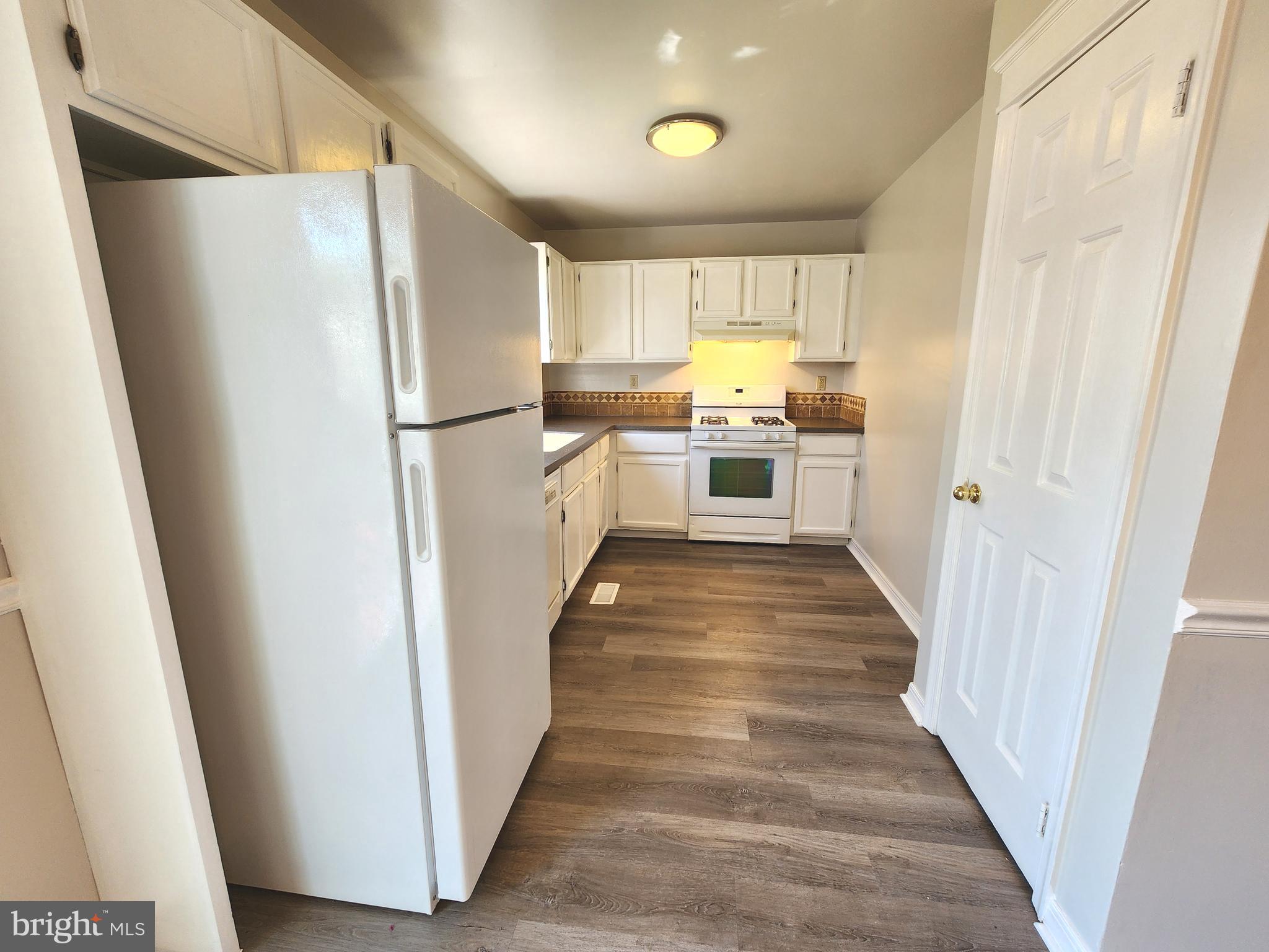 655 Knightsbridge Drive Hagerstown, MD 21740 - Photo 9 of 32 a kitchen with white cabinets and white appliances