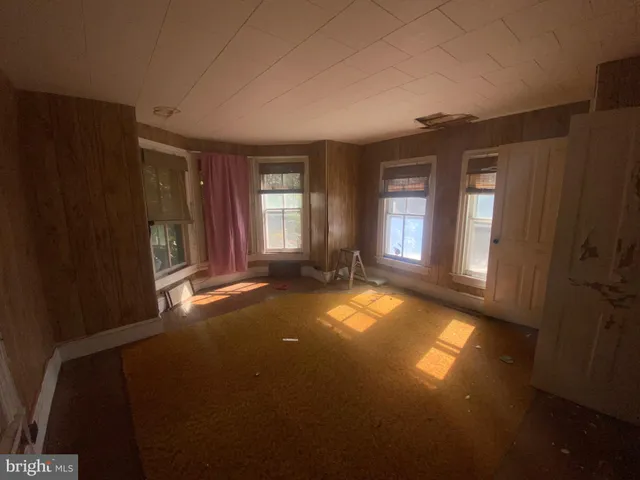 an empty room with windows and closet