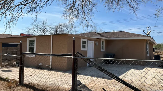 a view of a house with a wooden fence
