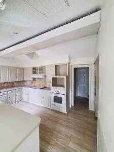 a large kitchen with cabinets stove top oven and sink
