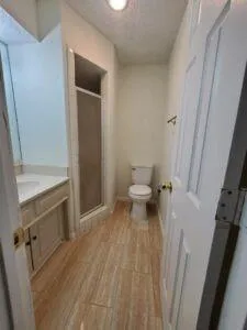 a view of empty room with wooden floor and fireplace