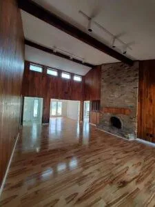 a view of empty room with wooden floor and fireplace