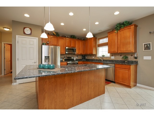 3038 Range Road Elgin, IL 60124 - Photo 3 of 10 a kitchen with stainless steel appliances granite countertop a sink a stove and a refrigerator