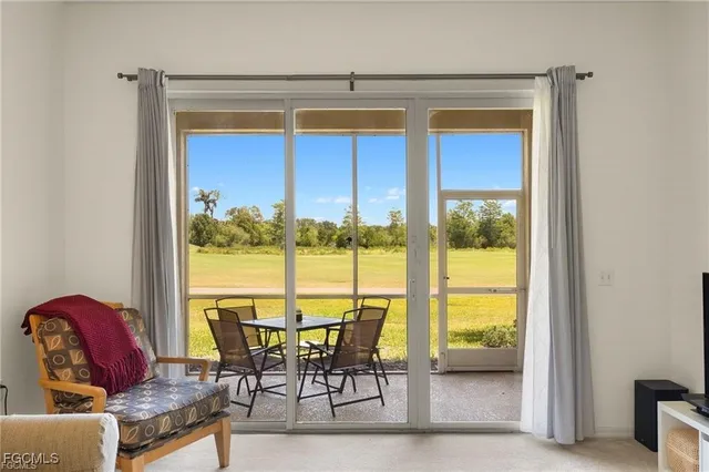 a view of a living room with furniture and floor to ceiling window
