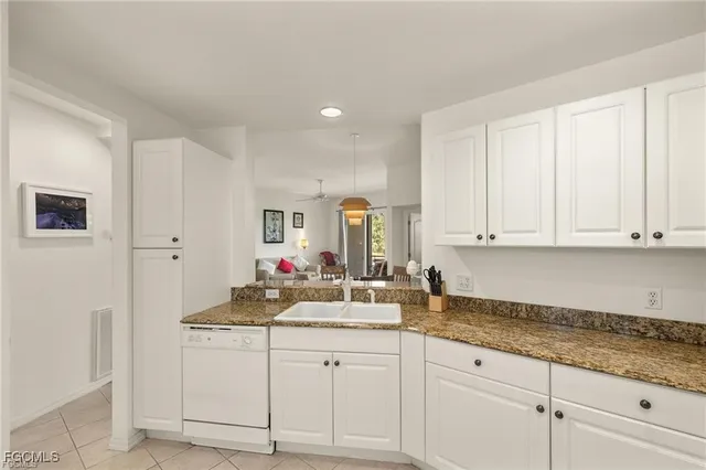 a kitchen with granite countertop white cabinets and white appliances
