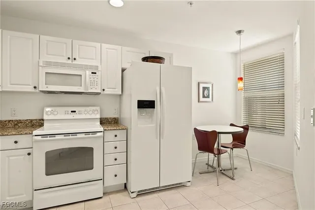 a kitchen with stainless steel appliances white cabinets and a stove top oven