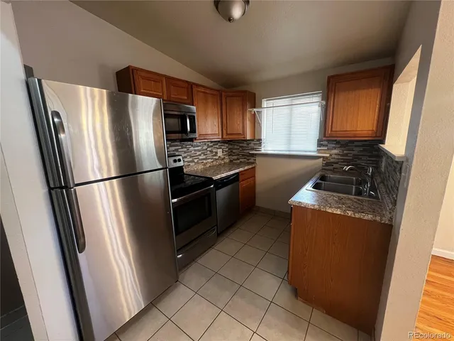 a kitchen with stainless steel appliances granite countertop a refrigerator and a stove