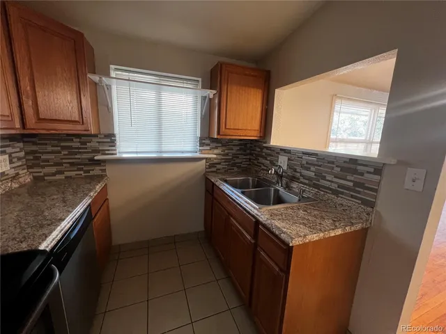 a kitchen with granite countertop a sink stove and cabinets