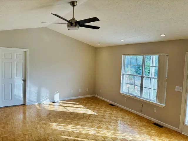 a view of a livingroom with a flesh screen tv and window