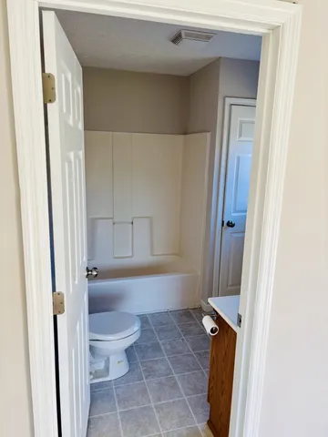 a bathroom with a toilet and a shower