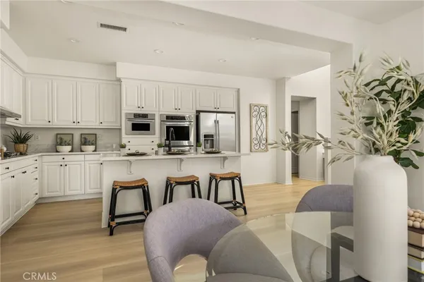 a kitchen with appliances a table and chairs in it