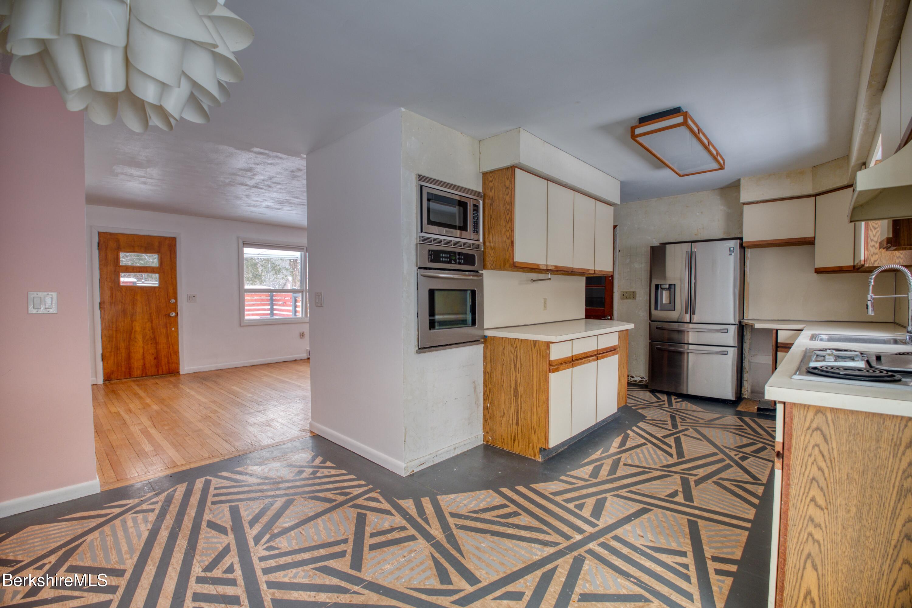 a kitchen that has a lot of cabinets and stainless steel appliances
