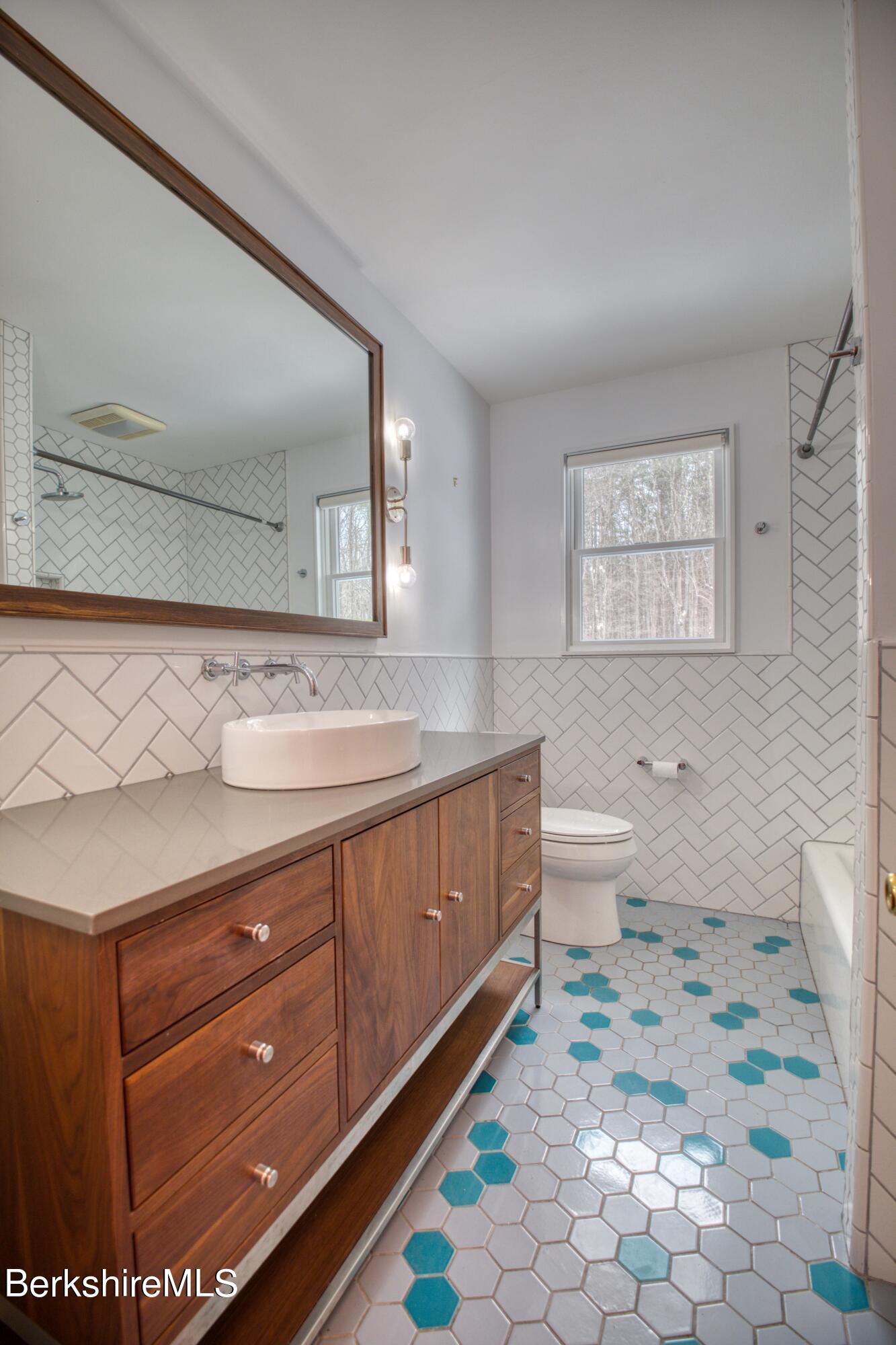 2500 State Road Richmond, MA 01254 - Photo 12 of 35 a spacious bathroom with a granite countertop sink a toilet and a mirror