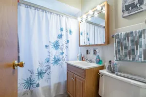 a bathroom with a granite countertop sink a mirror and a shower curtain