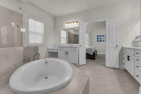 a bathroom with a tub sink and mirror