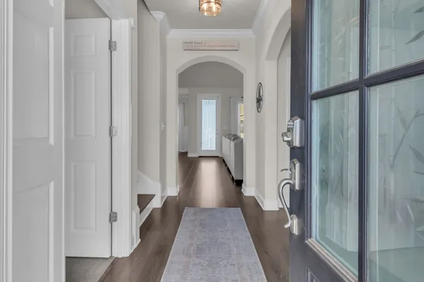 a view of a hallway with wooden floor and staircase