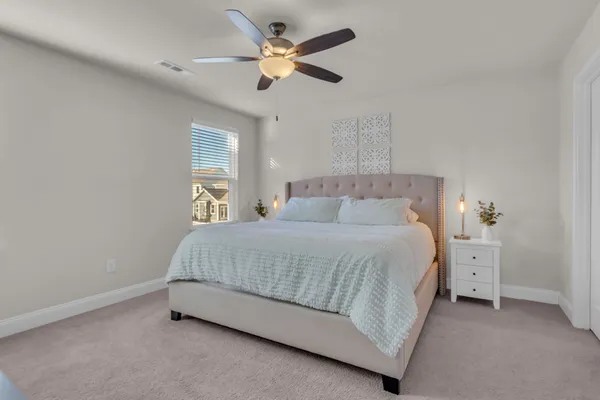 a bedroom with a bed and a flat tv screen on the dresser