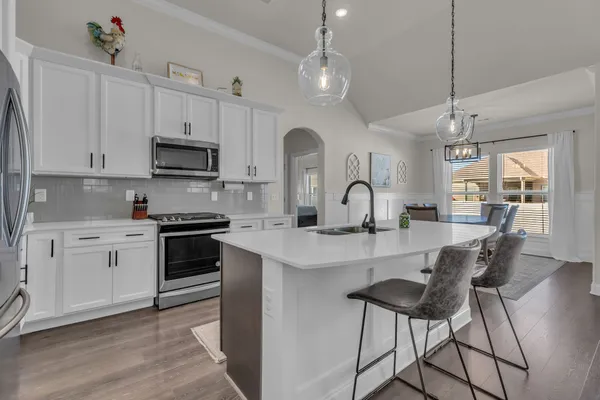 a kitchen with stainless steel appliances a sink stove and refrigerator