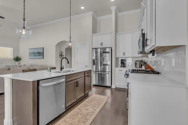 a kitchen with white cabinets and stainless steel appliances