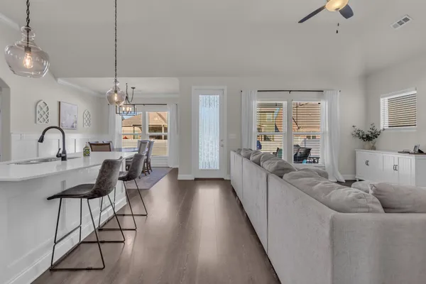 a large living room with stainless steel appliances granite countertop furniture a fireplace and a large window