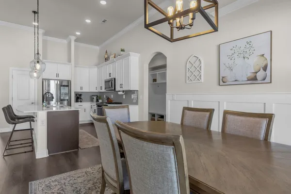 a dining room with wooden floor a glass table and chairs