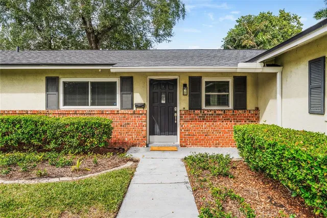 front view of a brick house with a small yard